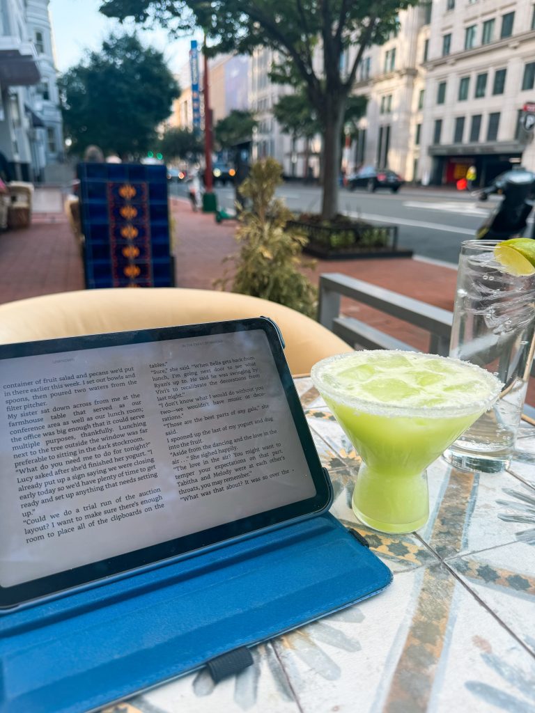 Photo of mini-ipad sitting on table with green cocktail.